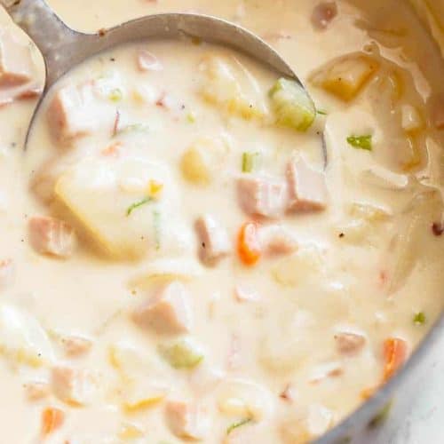 Creamy Ham And Potato Soup in a bowl being scooped up by a spoon before being eaten