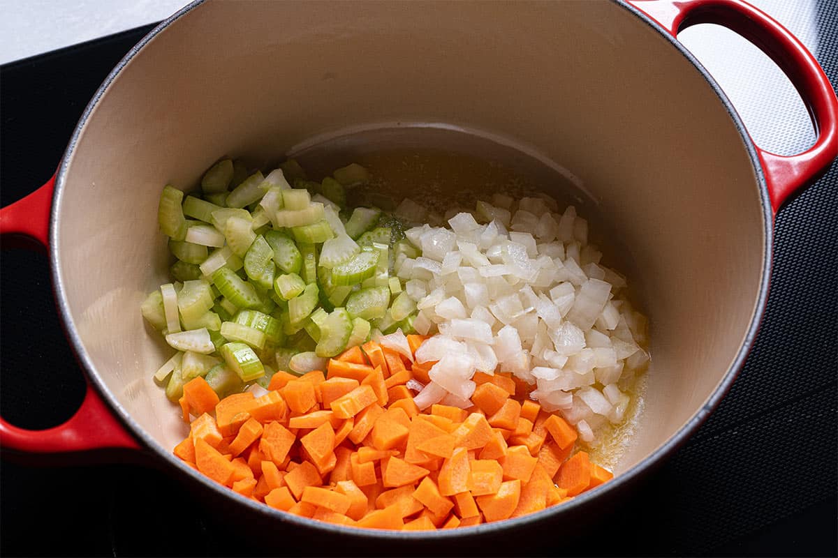 Image of carrots, onions, and celery being sautéed in a pan.