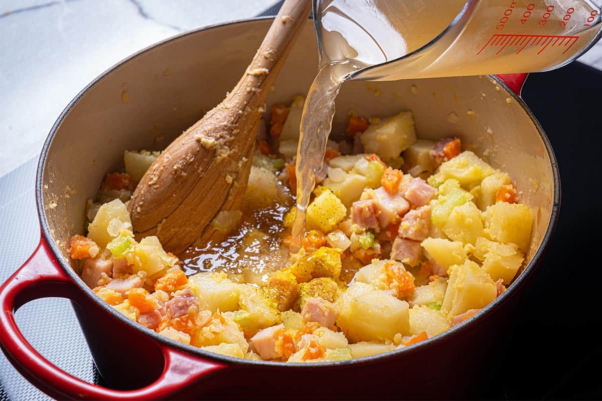 Image of stock being added to the mix of veggies.