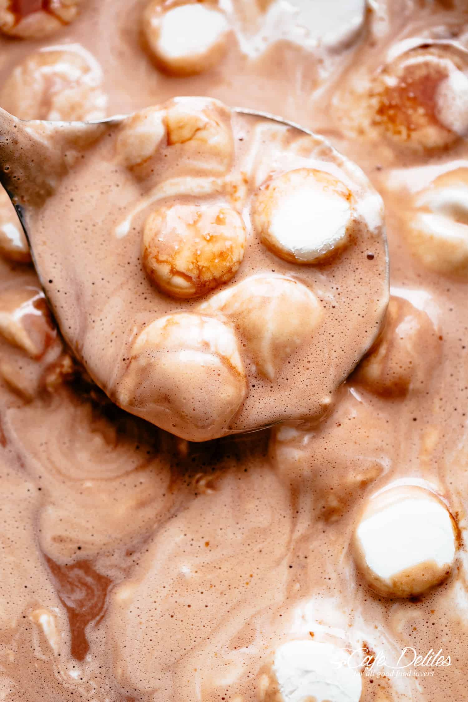 Creamy and decadent Hot Chocolate made in a slow cooker with cocoa powder, chocolate chips in milk, evaporated milk or heavy cream and marshmallows! | cafedelites.com