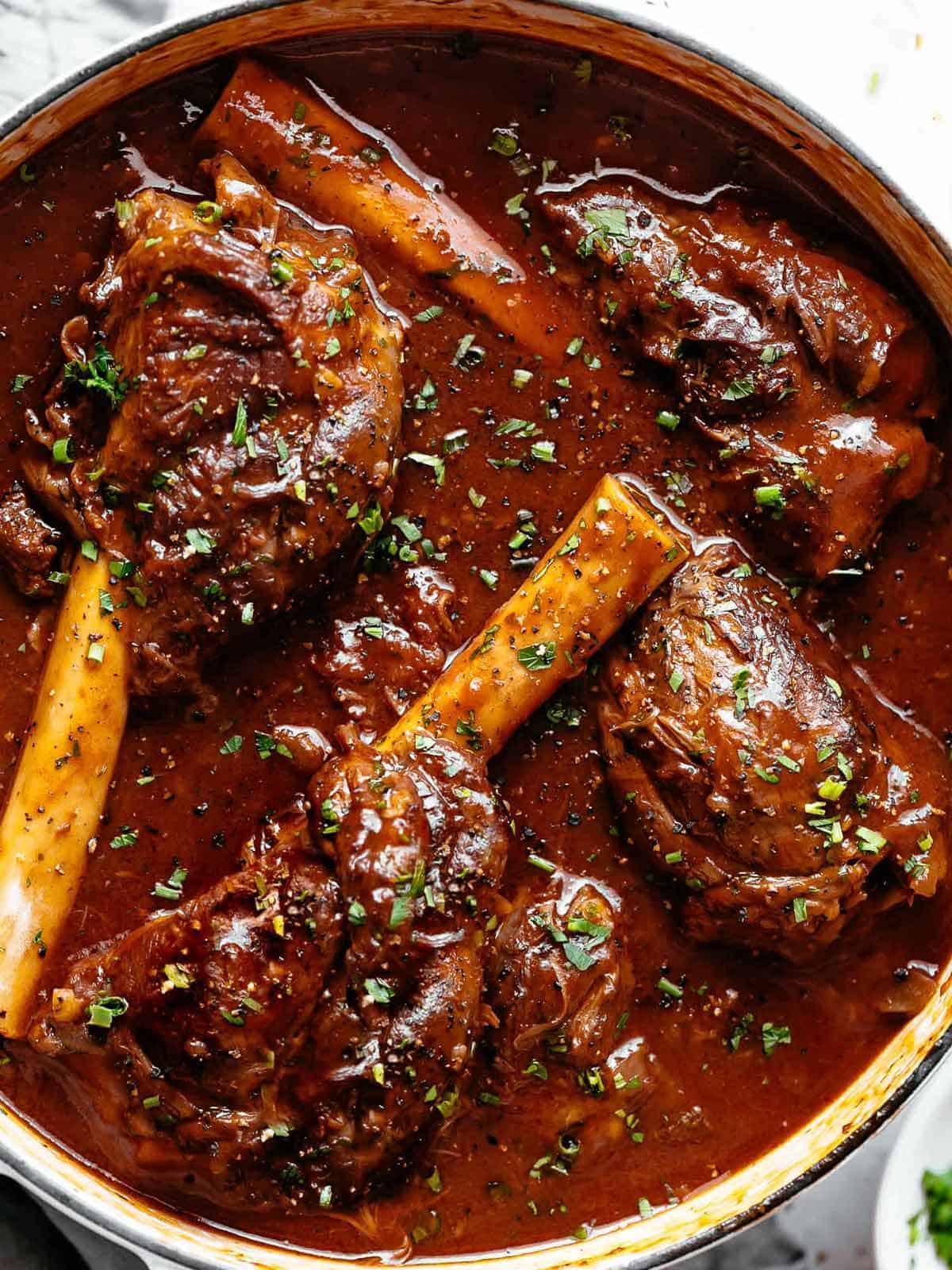Tender, fall off the bone easy braised Lamb Shanks in a luxuriously delicious red wine gravy! Can be Cooked in Oven or stove top or slow cooker or Instant pot.