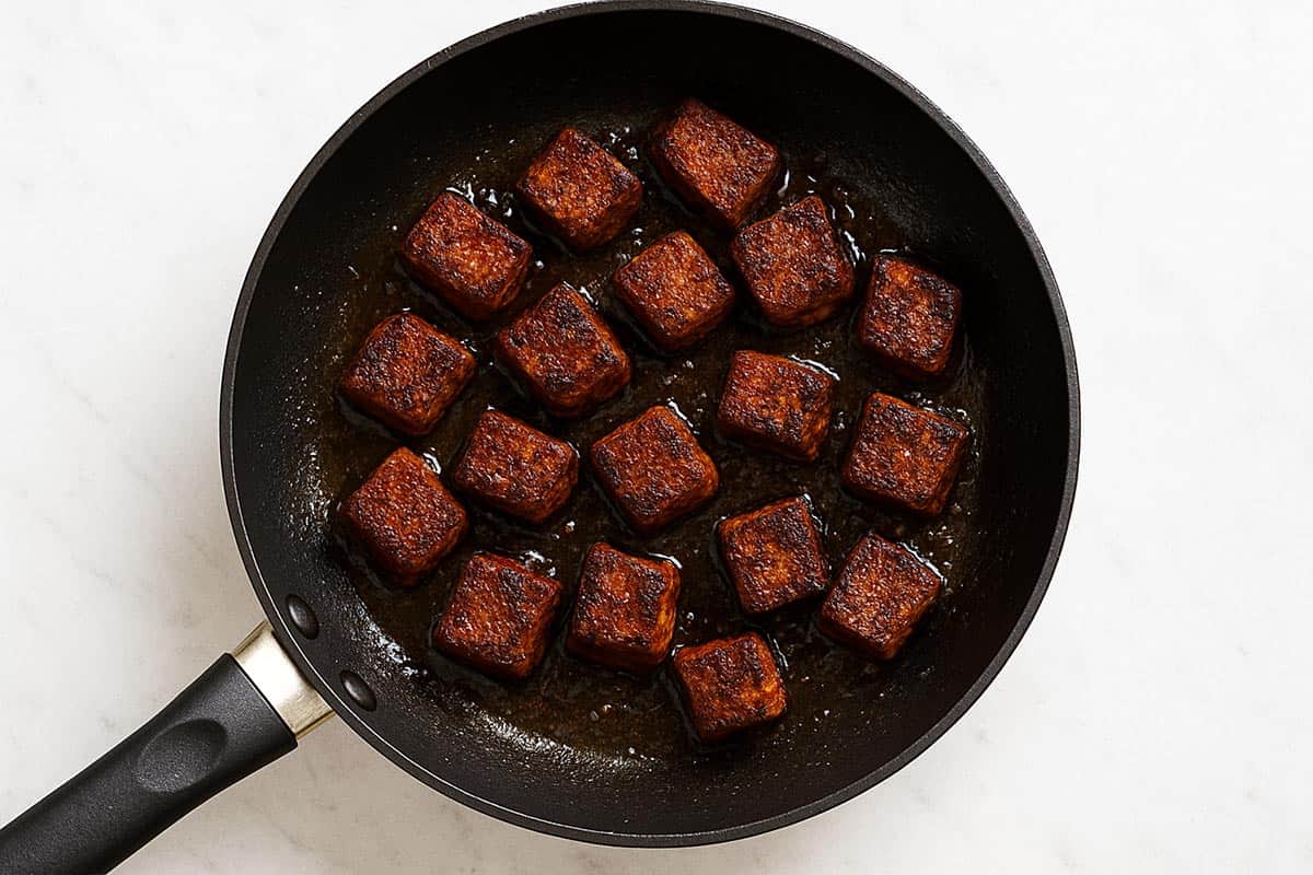 seasoned steak being seared in a pan