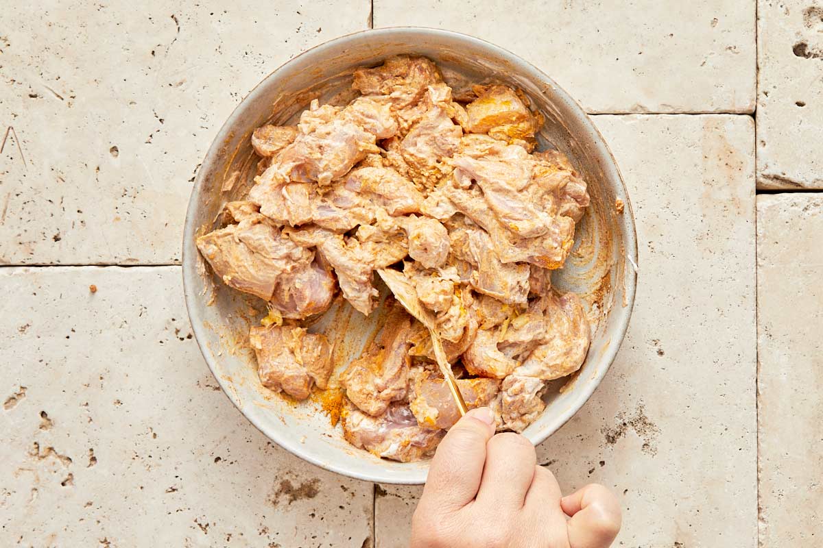 Marinated chicken in plain yogurt and spices, in a bowl.