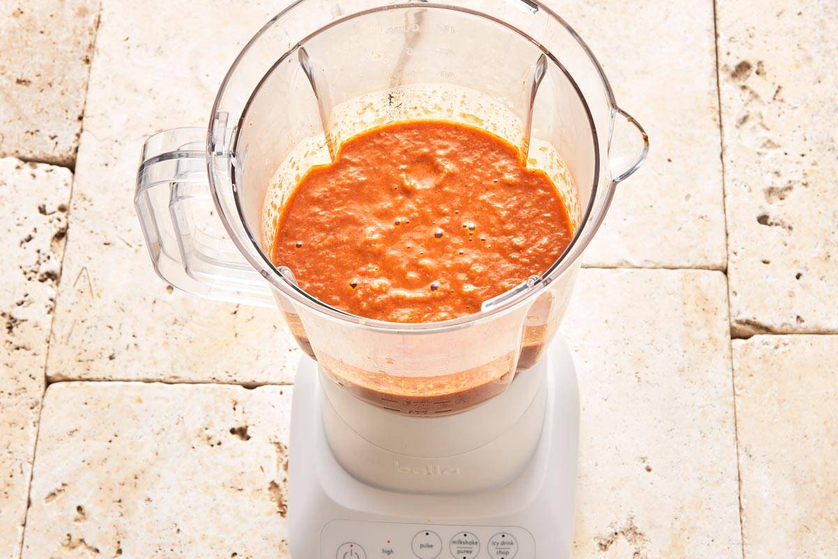 Image of the sauce, previously sautéed in a skillet, being blended in a blender for a velvety and creamy texture.