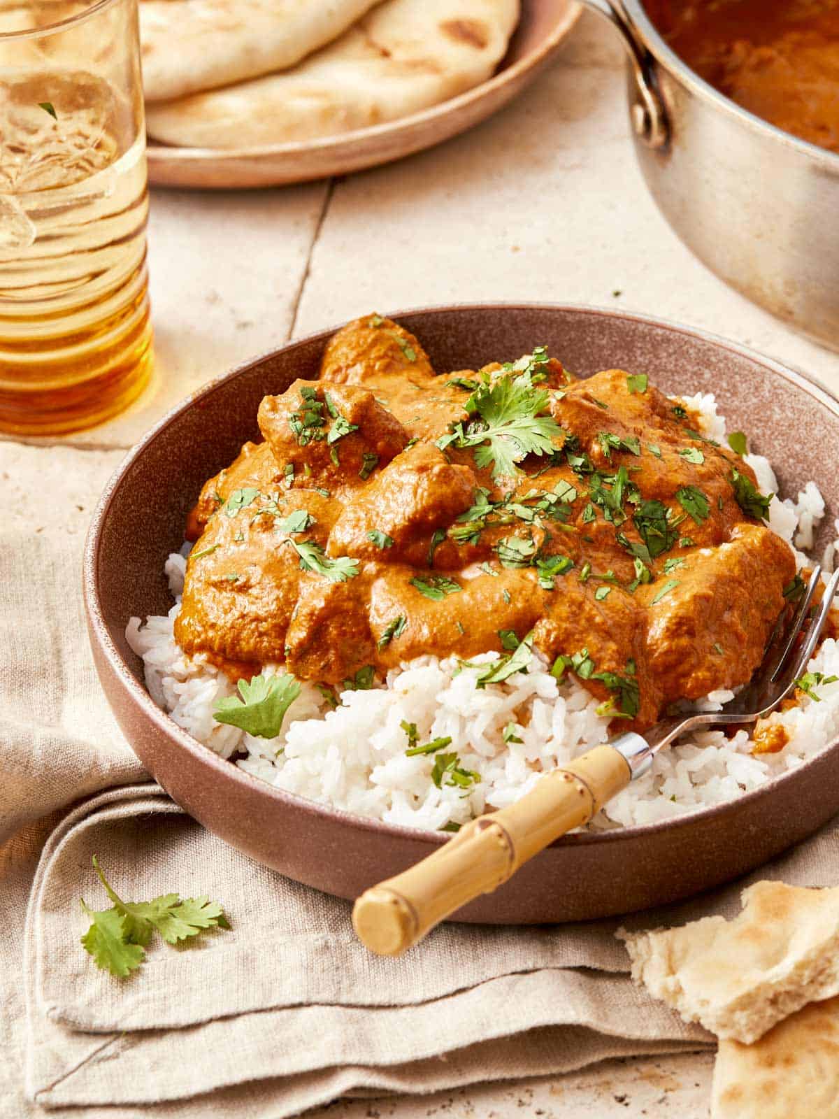 Butter chicken served over rice and naan in a bowl looks yum
