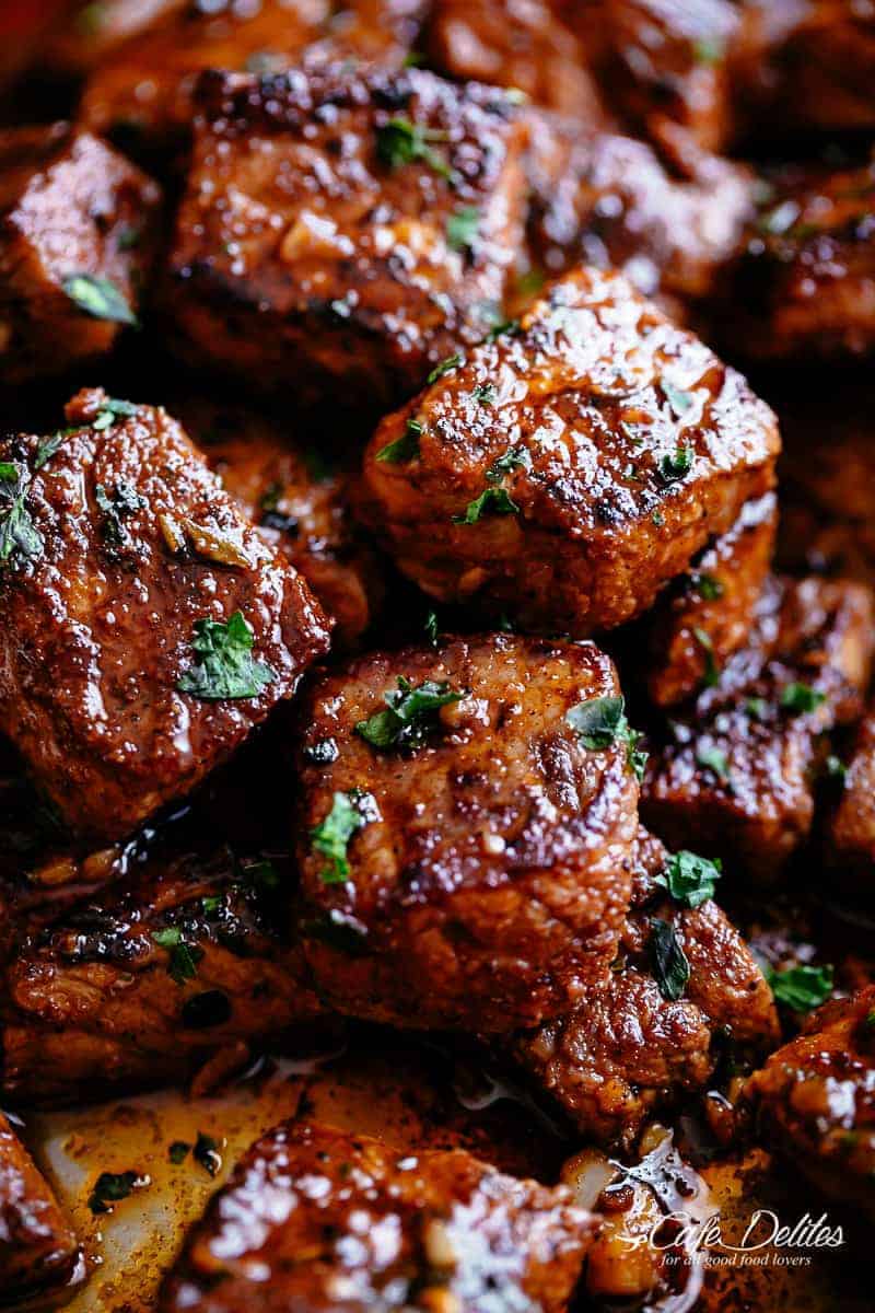 A close up of steak bites fried in cajun butter seasoning