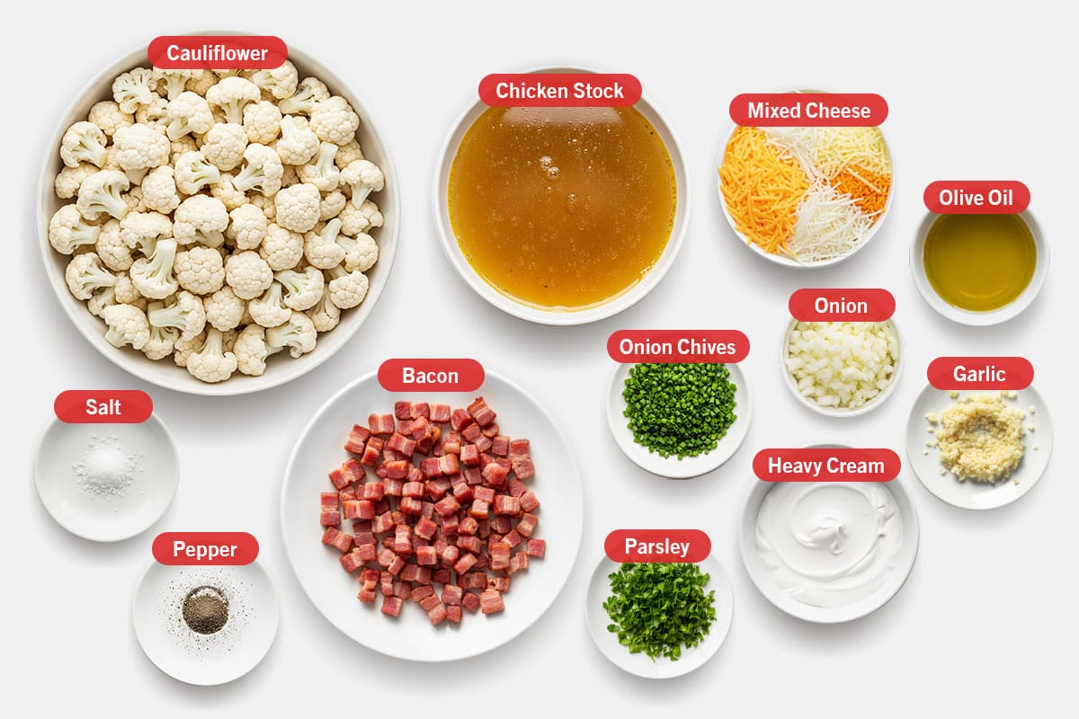 Top shot of ingredients: Cauliflower, chicken stock, mixed cheese, salt, pepper, bacon, onion chives, parsley, onion, heavy cream, olive oil, and garlic.