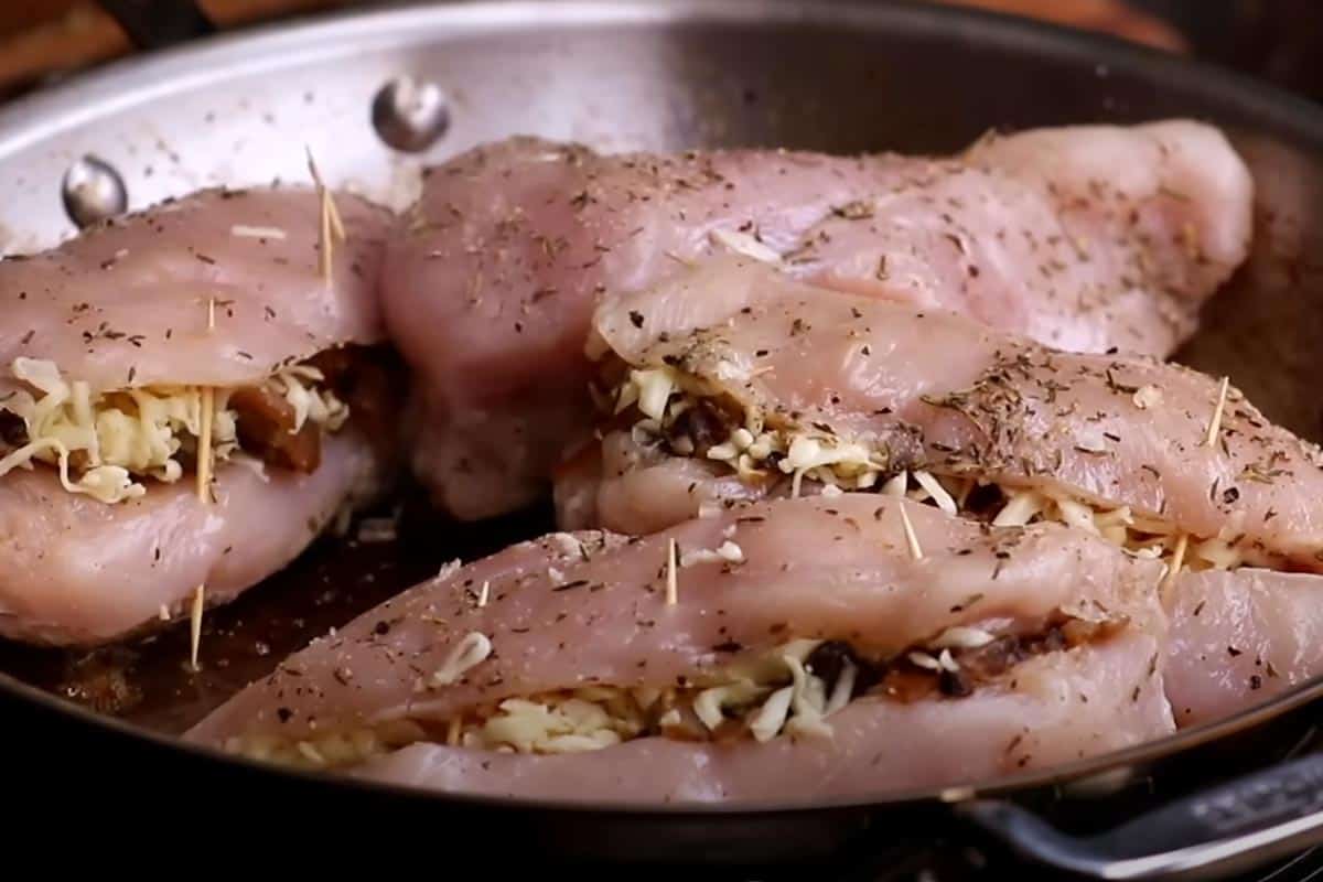 Searing the chicken in the pan.