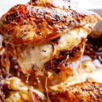 French Onion Stuffed Chicken piece being pulled out of casserole