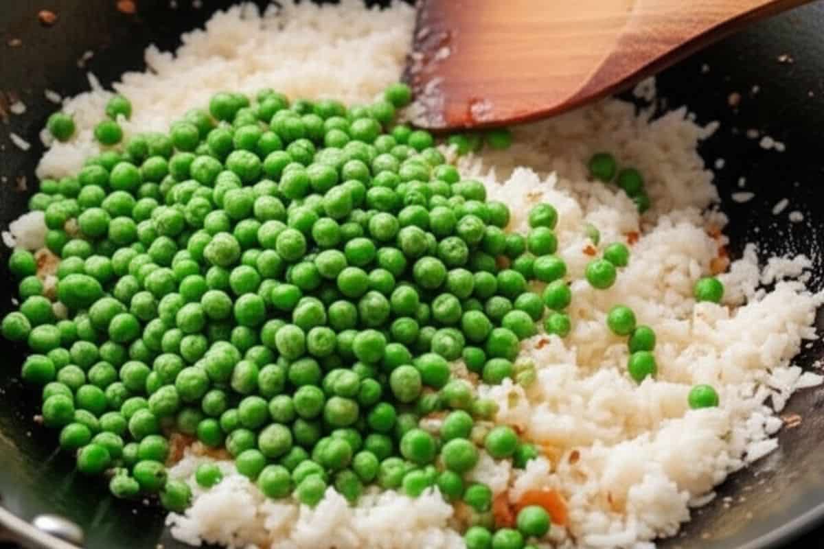 add the cold cooked rice and peas to the wok