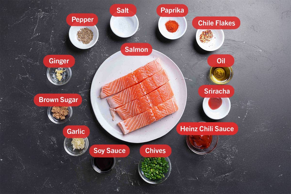 Image of the ingredients needed for the preparation of the recipe, specifically: salmon, paprika, chili flakes, oil, sriracha, heinz chili sauce, chives, soy sauce, garlic, brown sugar, ginger, pepper, salt