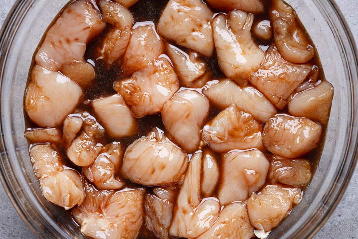 diced chicken being marinated in a bowl