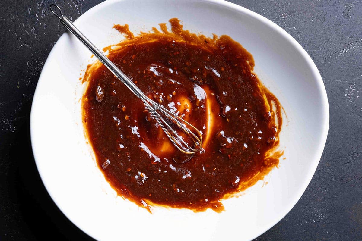 An image of the ingredients for the sauce being whisked together to create the sauce that will be used to coat the salmon.