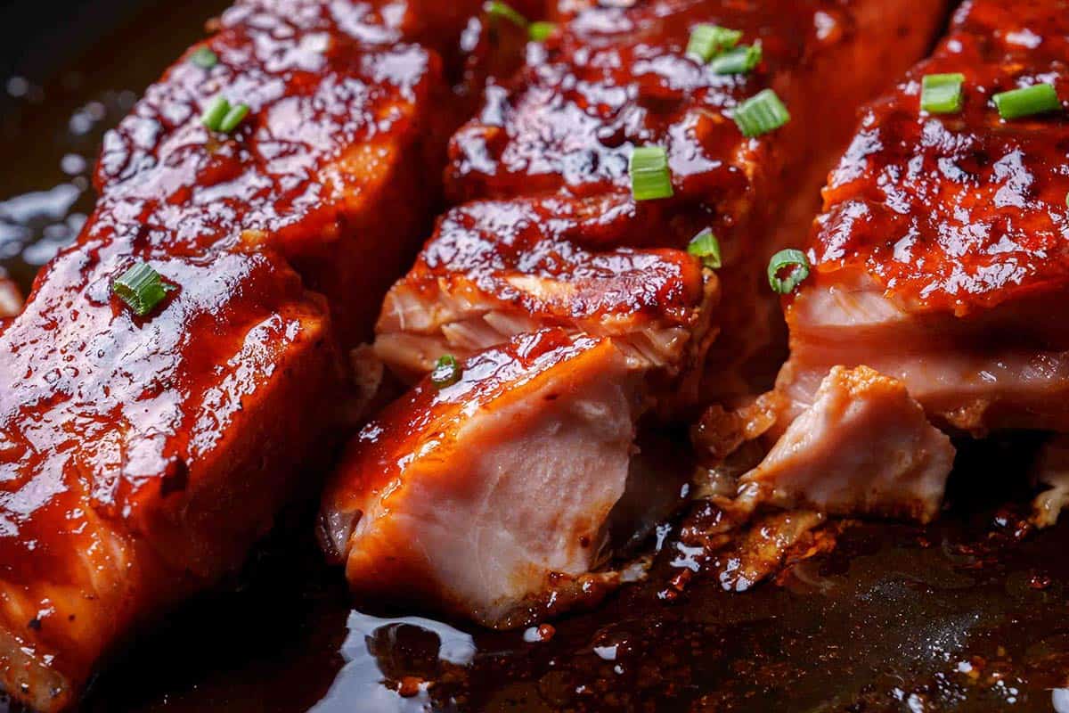 Close-up image of the tender and flaky salmon served on a baking tray.