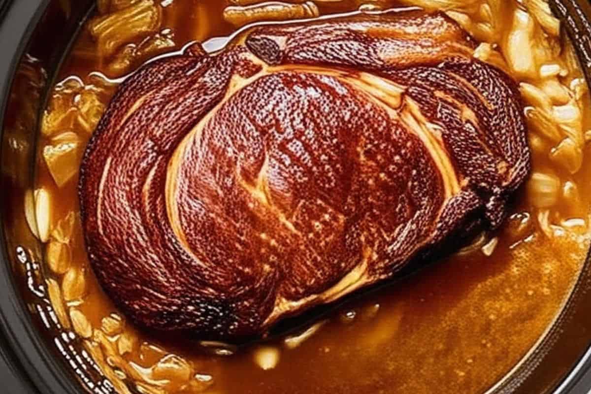 Seared roast in a 6-quart slow cooker with sautéed onions, French onion soup, beef consommé, stock (or beer), and Worcestershire sauce.