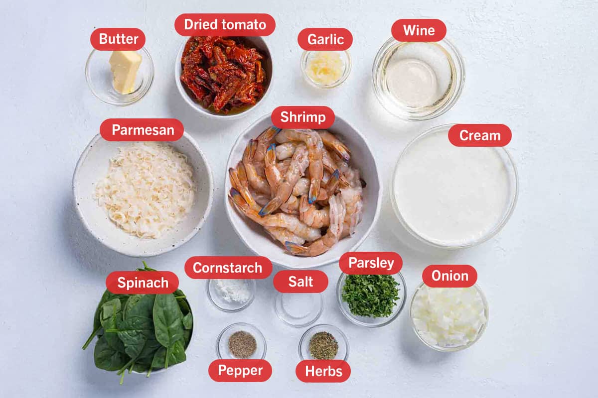 Image of the ingredients needed for the preparation of the recipe, specifically: shrimp, Parmesan, butter, dried tomatoes, garlic, wine, cream, spinach, cornstarch, salt, parsley, onion, pepper, and herbs.