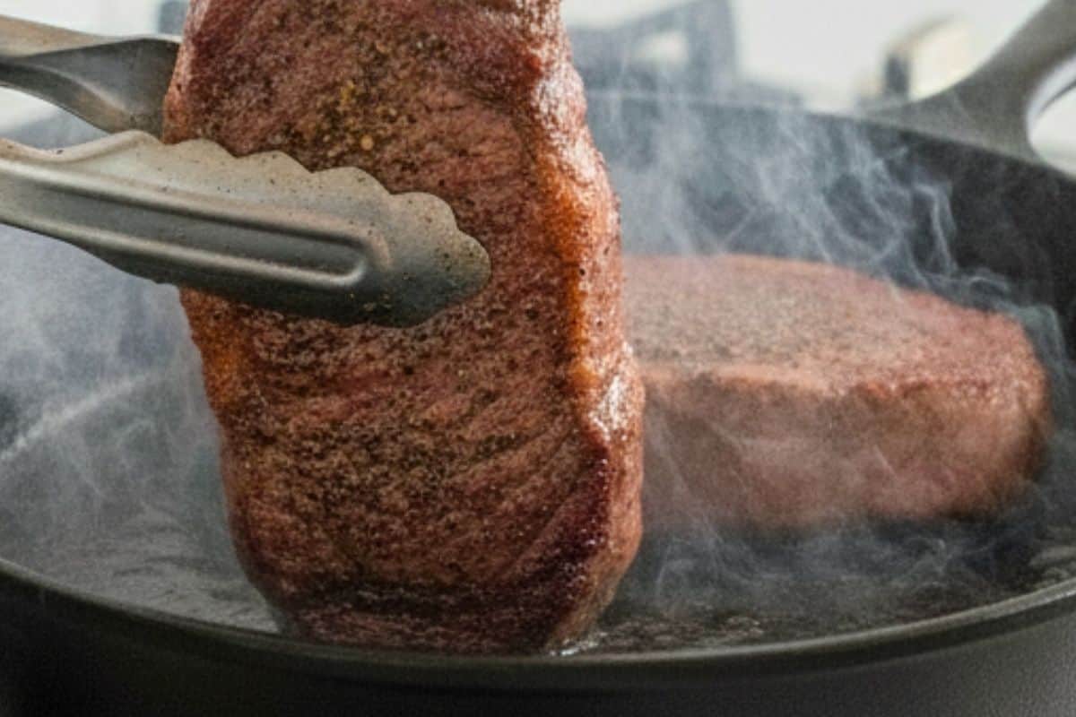 Using tongs, hold each steak upright to sear the fat caps and sides for about 1 minute.