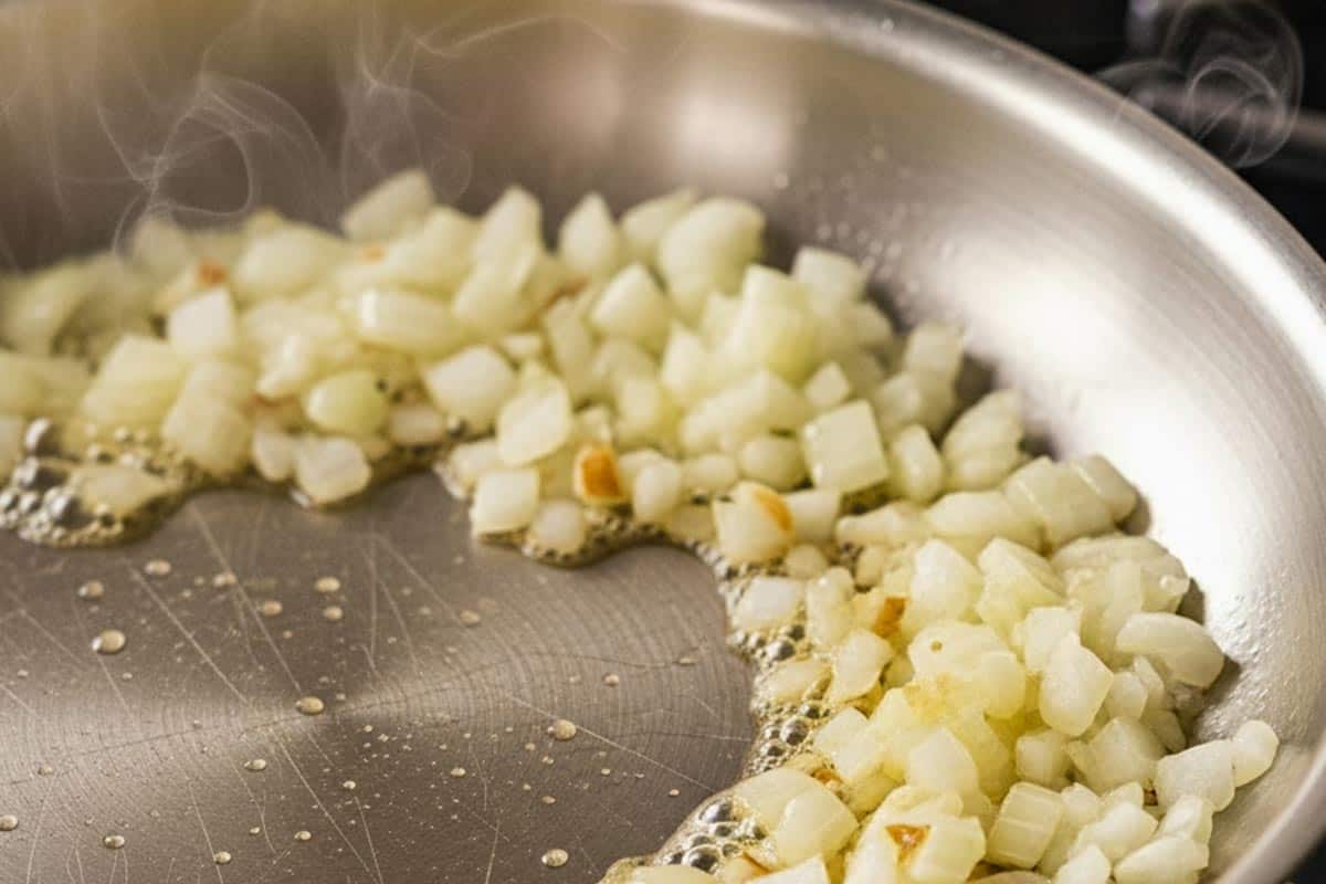 Cooking onion with melted butter in a skillet.