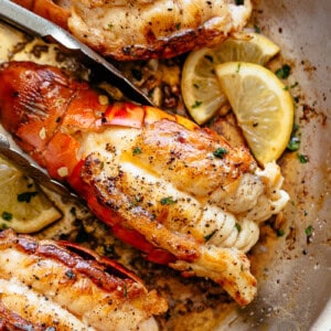 Stove Top Garlic Butter Seared Lobster Tails with lemon wedges