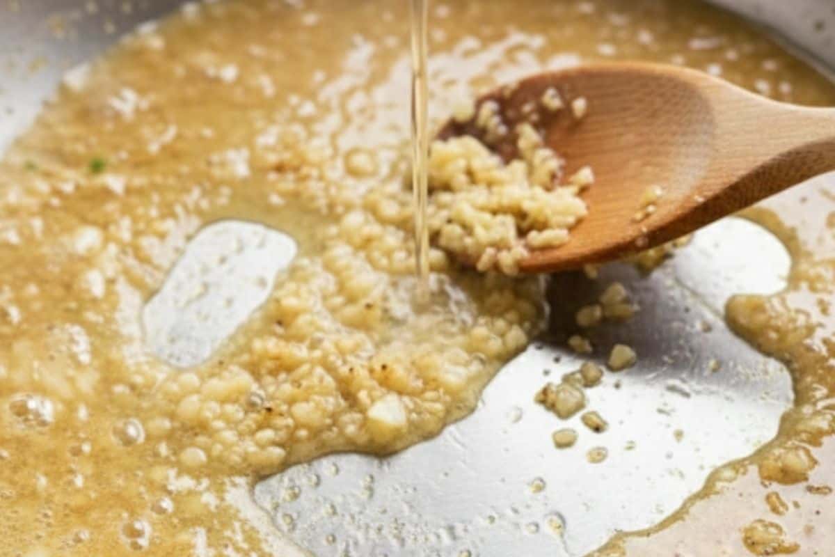 Melt butter in skillet, sauté garlic until fragrant, then pour in chicken stock.