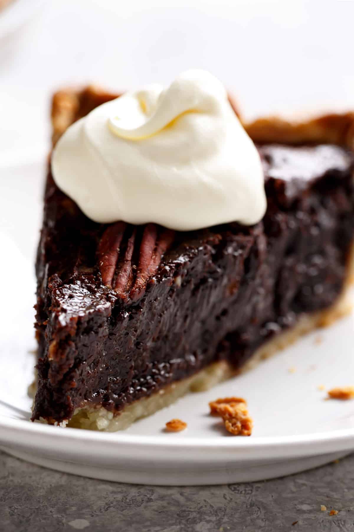 Close up photo of a slice of the finished pie, topped with a dollop of whip cream on top. 