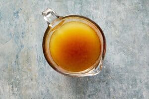 Strained turkey cooking liquid in a measuring jug for gravy