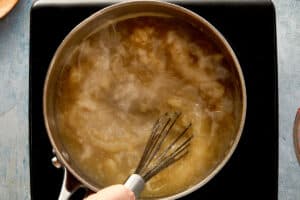 Thickening turkey gravy being whisked in saucepan until smooth and glossy