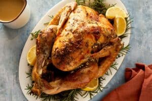 Crispy skin slow cooker whole turkey served with homemade gravy and fresh herbs