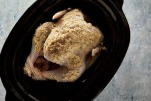 Raw whole turkey coated with herb butter and seasoning