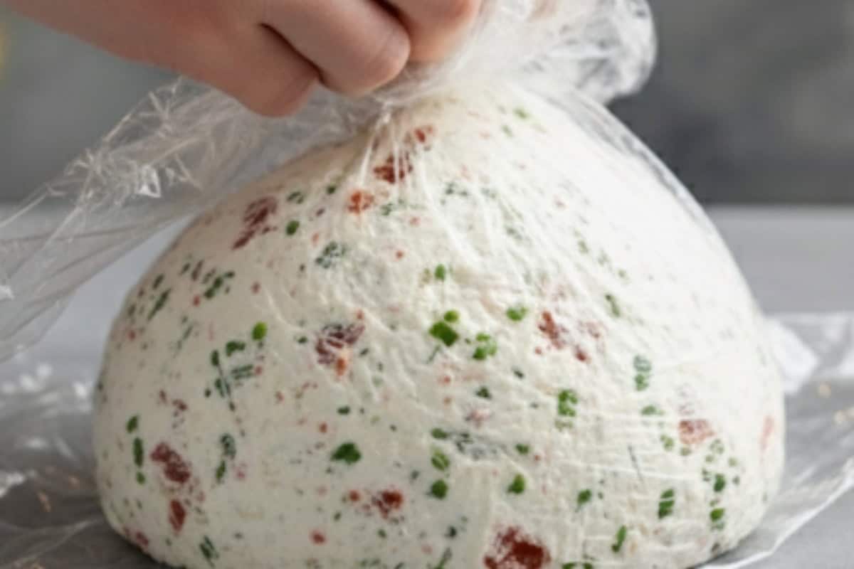 Lay a large sheet of plastic wrap on your work surface and scoop the mixture onto the center. Cover completely with a second sheet of wrap,