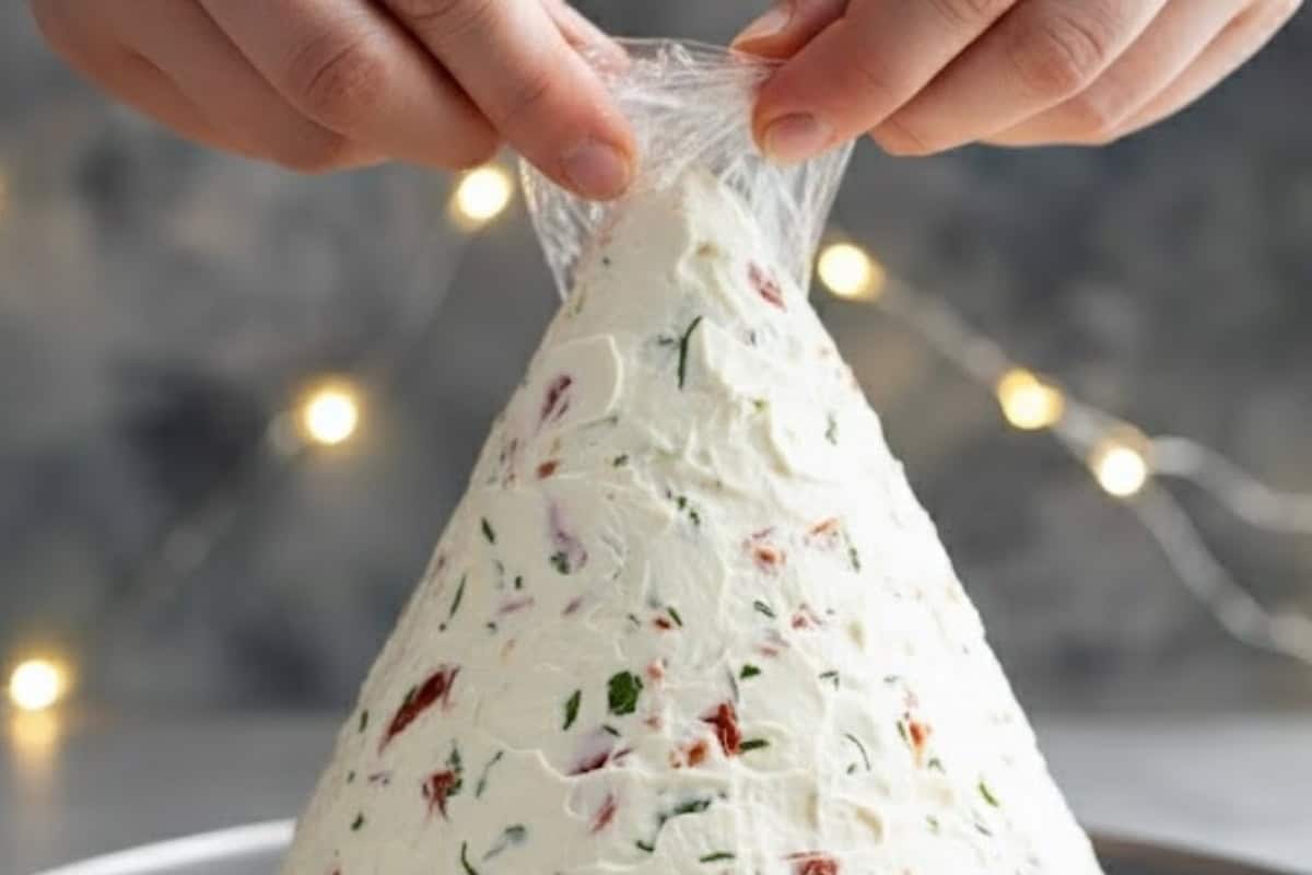 Using your hands, mold into a cone that resembles a Christmas tree. Lift the cone, peel away the bottom layer of wrap.