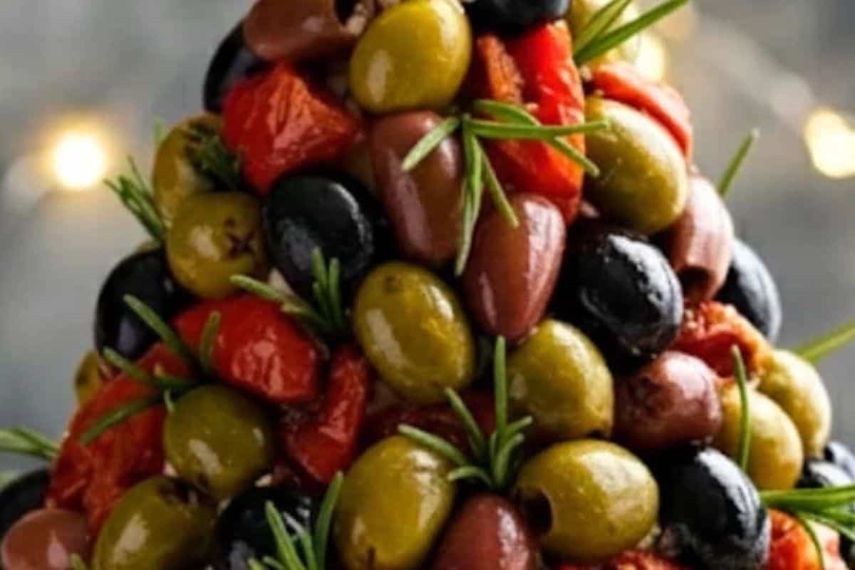 Press olives, sun-dried tomatoes, and rosemary leaves or sprigs into the surface, spacing them like ornaments.