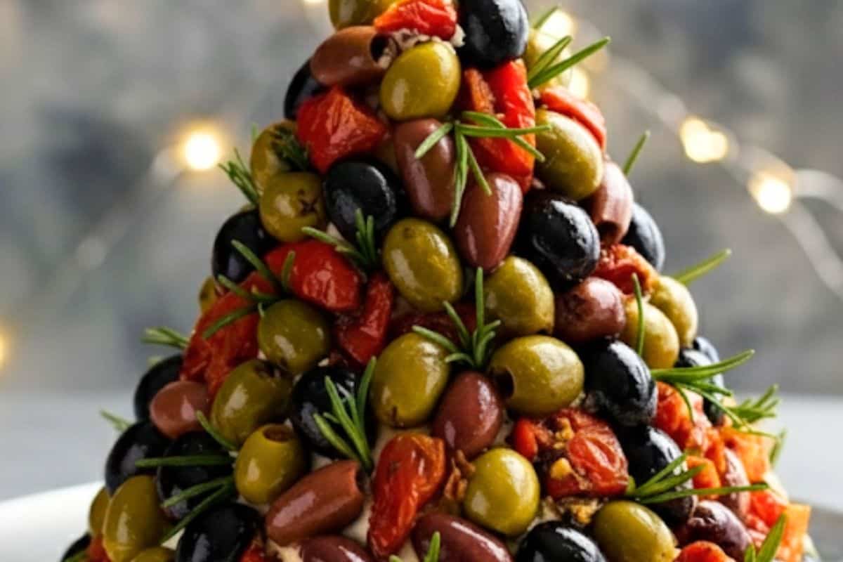 Press olives, sun-dried tomatoes, and rosemary leaves or sprigs into the surface, spacing them like ornaments.