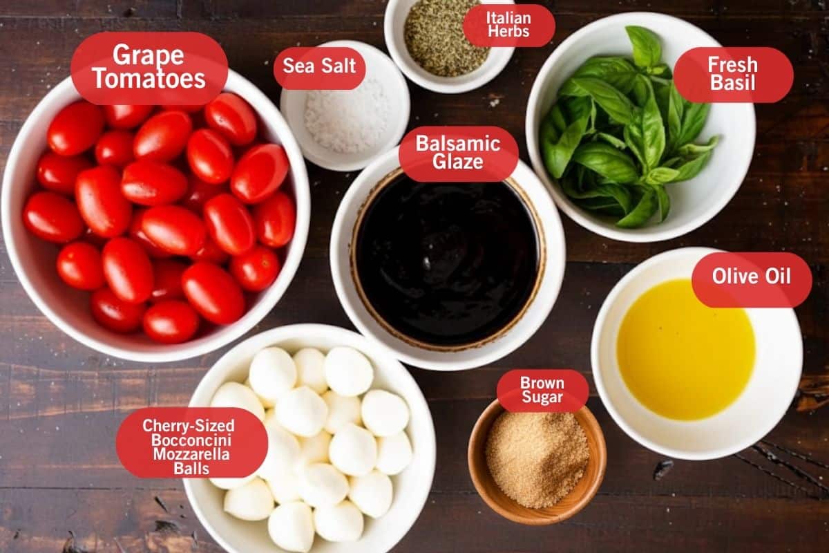 Flat lay photo of ingredient shot of grape tomatoes, sea salt, Italian herbs, fresh basil, balsamic glaze, olive oil, brown sugar, cherry sized bocconcini mozzarella balls