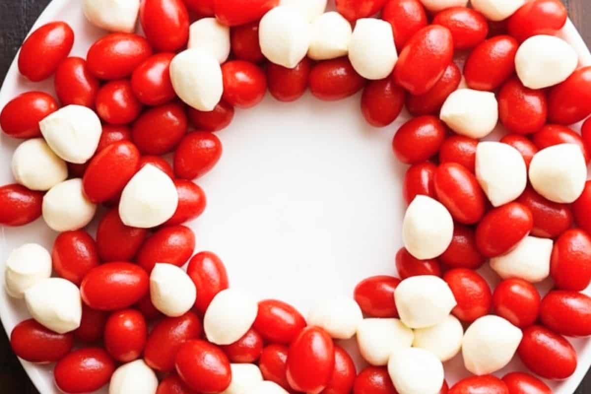 Arrange the tomatoes and arrange the cherry sized bocconcini and tuck them in a round platter.