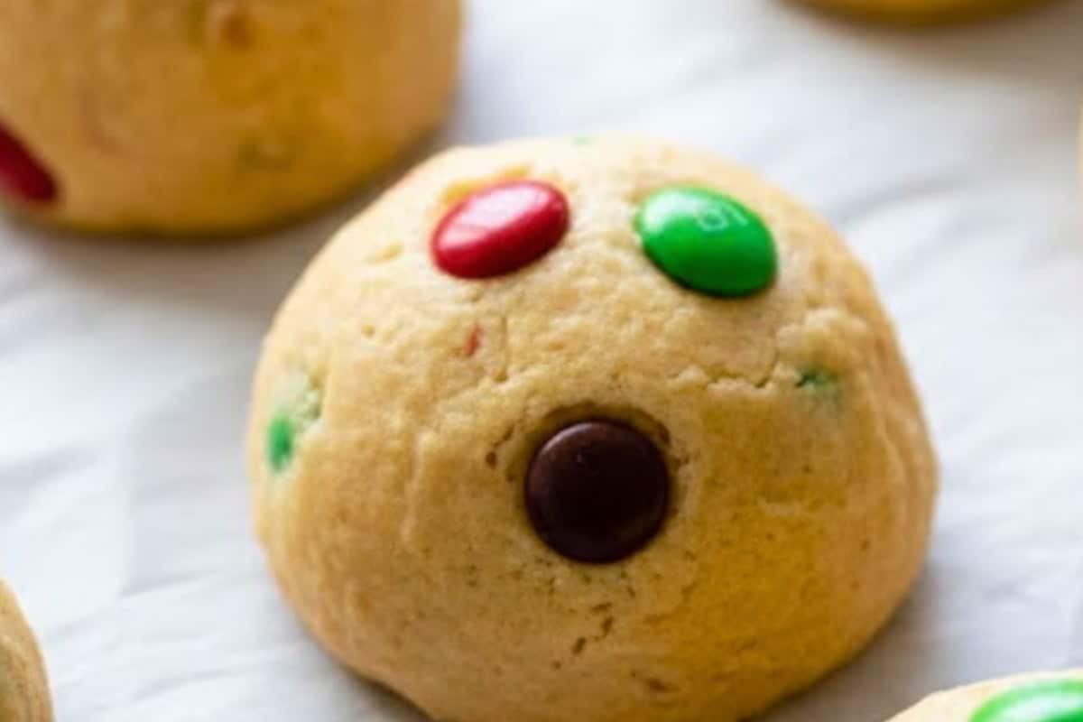 Scoop out 18 to 20 cookie balls and place them on your prepared baking sheet. Press the remaining M&M’s and chocolate chips on top of each ball.