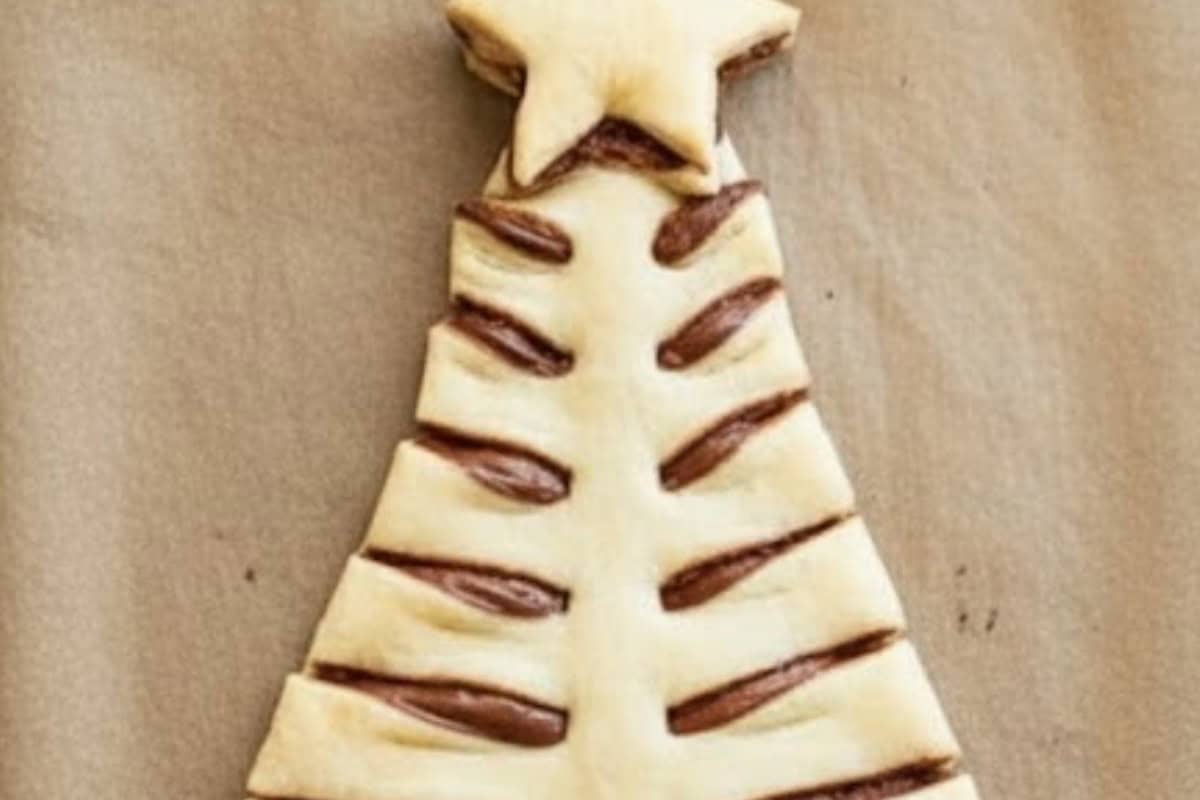 Cut out both the puff pastry sheets in the shape of a Christmas tree. Spread Nutella evenly on the top of one of the trees, and carefully place the second tree on the top. Transfer to the lined baking sheet.