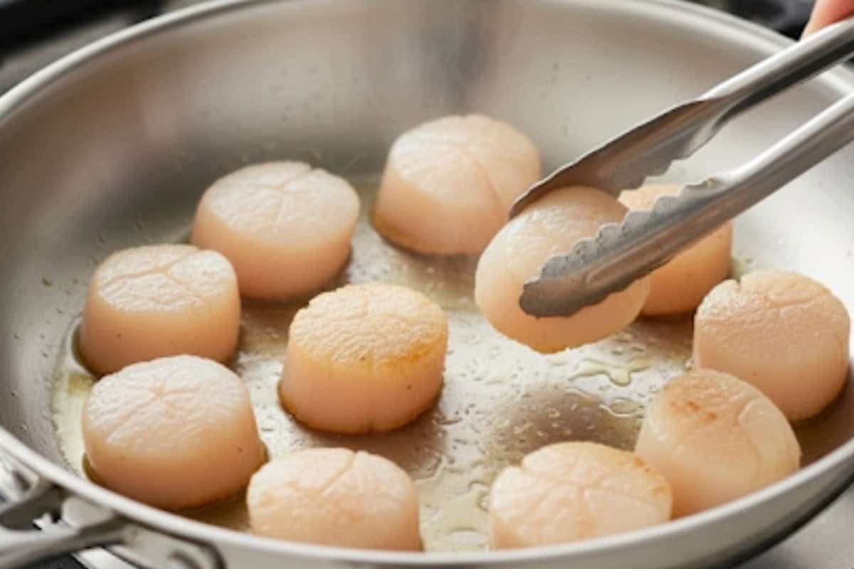 Add scallops in a single layer without crowding. Sear 2 to 3 minutes until a golden crust forms
