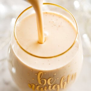 pouring eggnog into a fancy glass cup