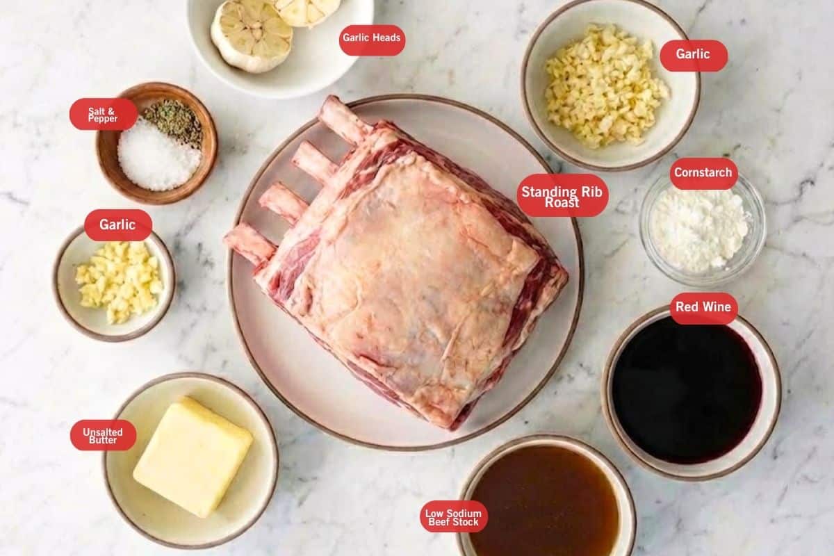 Flat lay of standing rib roast, head garlic, unsalted butter, garlic, salt and pepper, low sodium beed stock, red wine, cornstarch - 2