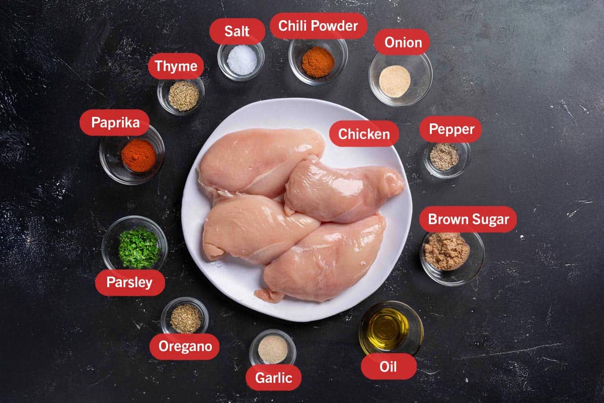 Image of the ingredients needed for the preparation of these oven baked chicken breasts: chicken, chili powder, onion, pepper, brown sugar,oil, garlic, oregano, parsley, paprika, thyme, and salt.