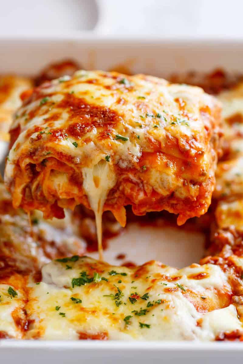 Close-up image of a lasagna slice ready to be served on a plate.