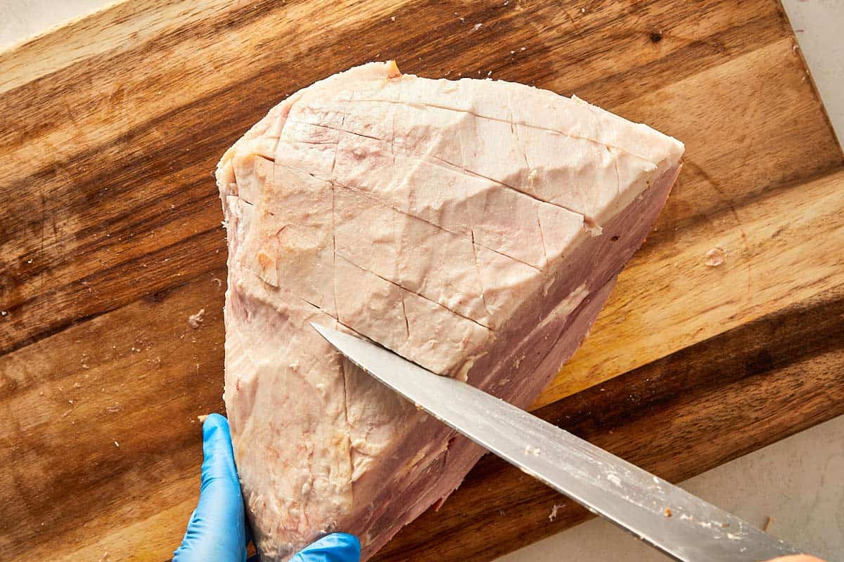 scoring the ham with a knife cutting shallow cut