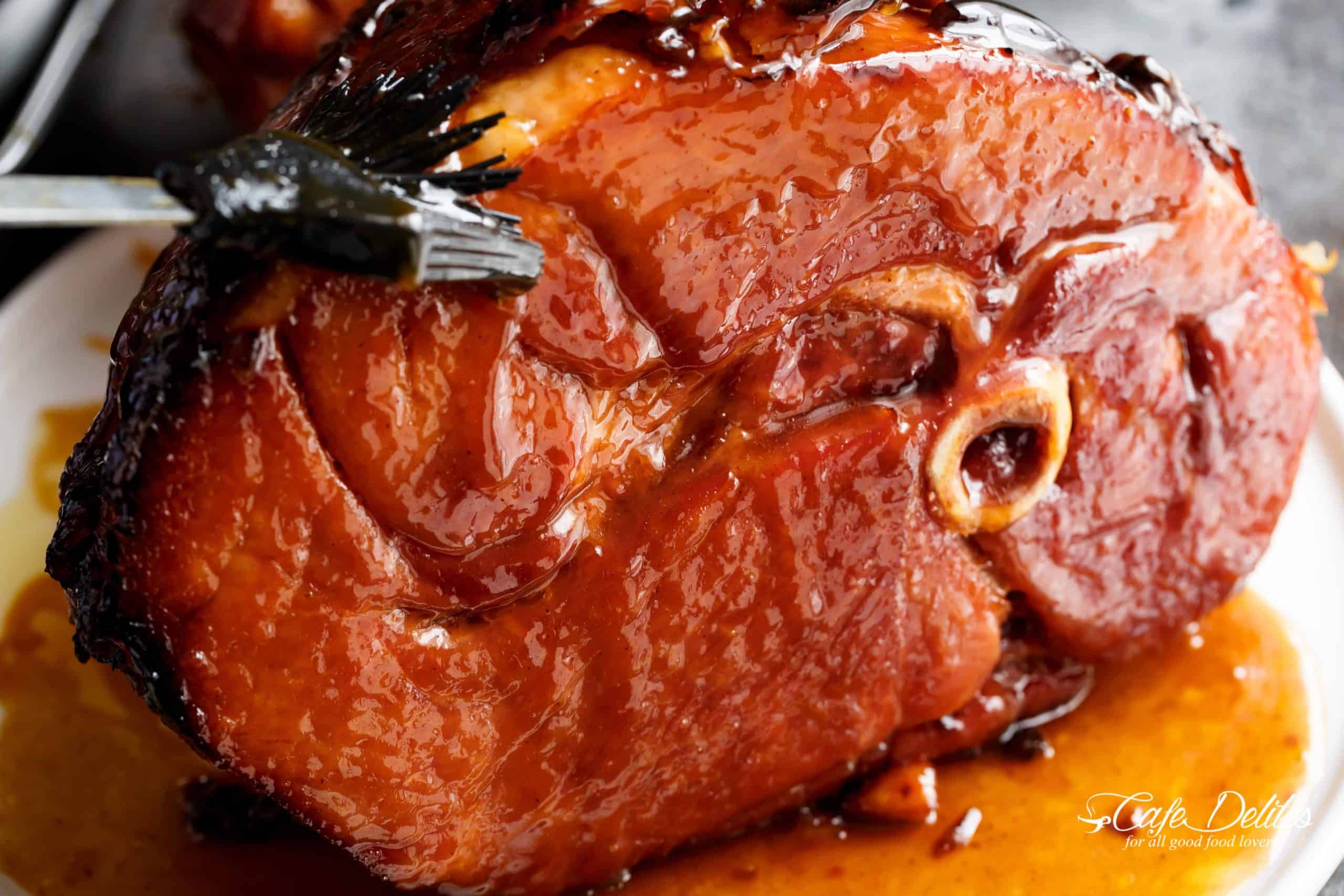maple glazed ham on it's side with bone in and juicy glaze running down