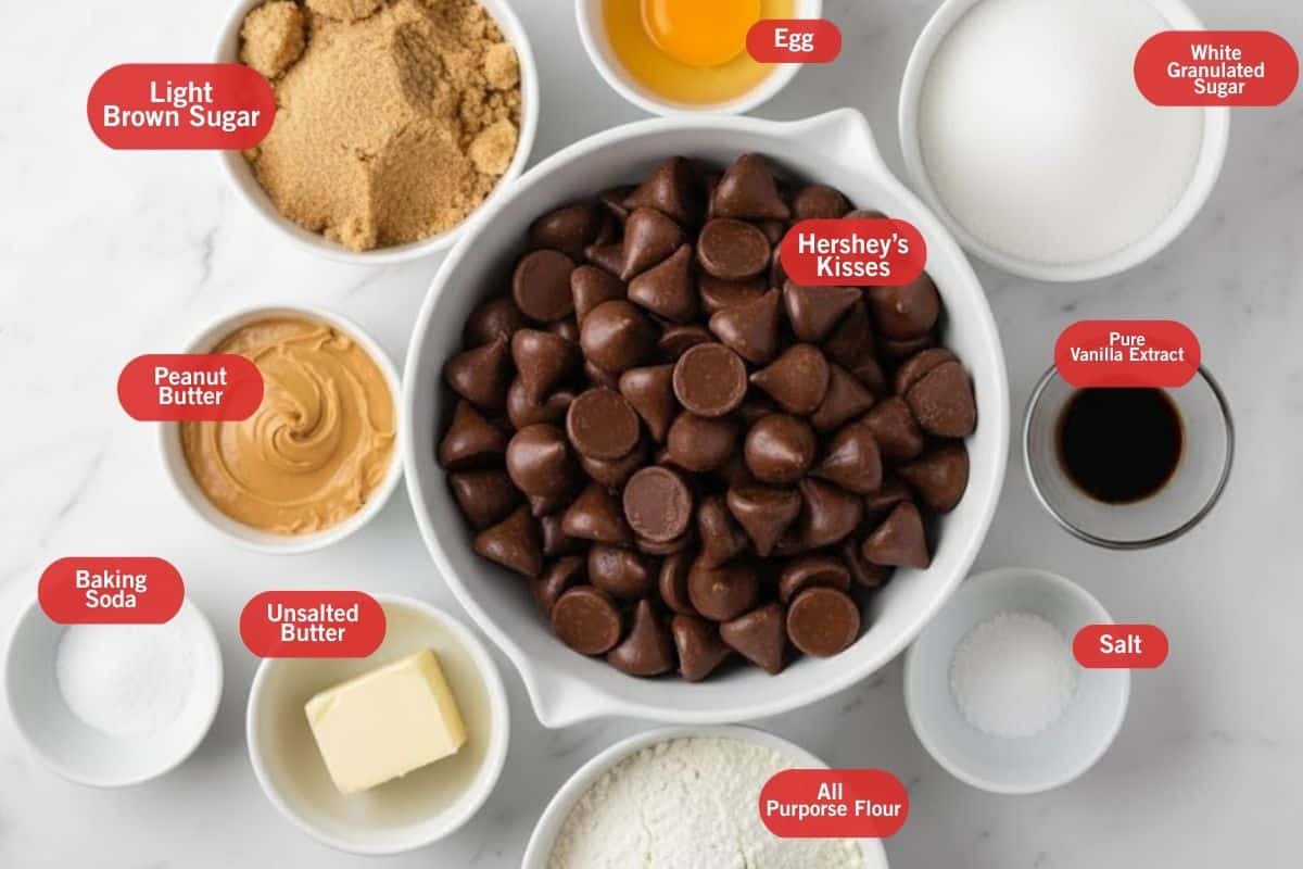 Flat lay photo of ingredient shot of light brown sugar, egg, white granulated sugar, pure vanilla extract, salt, all purpose four. Hershey's kisses, peanut butter, baking soda, unsalted butter, 