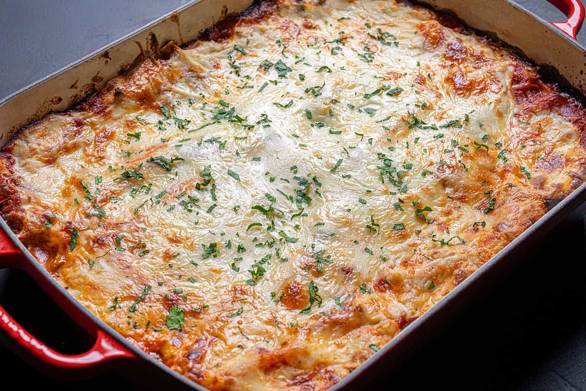 Image of lasagna being taken out of the oven, ready to be served.