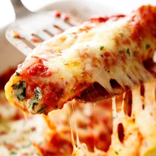 A spatula holding Spinach Cheese Manicotti