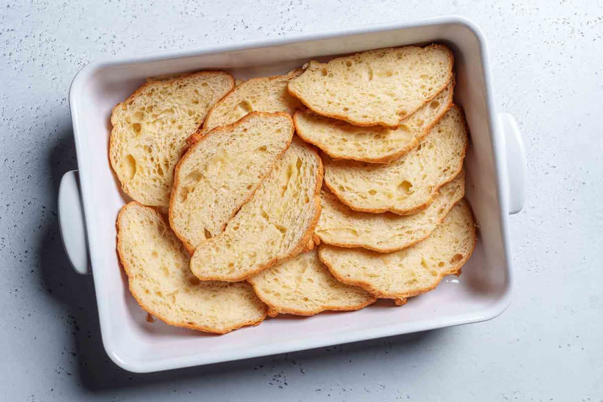 Image of the halved croissant laid out in a greased baking tray.