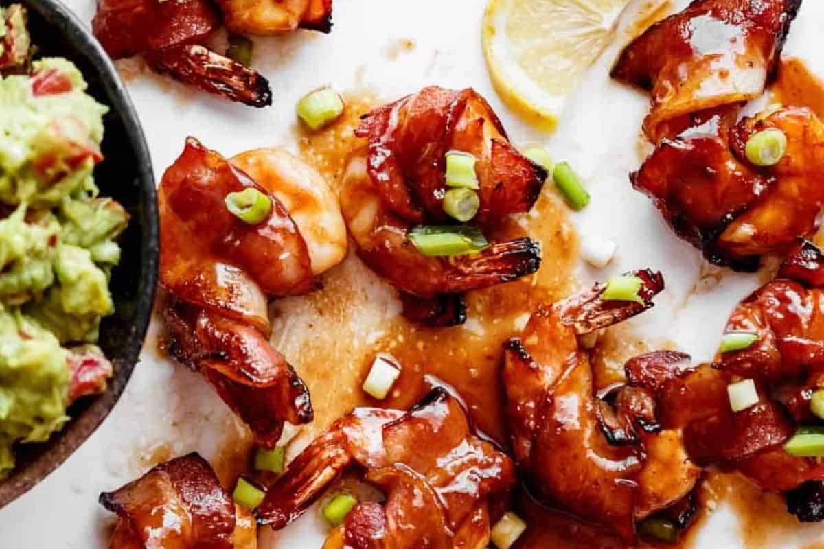 Drizzle with the reserved sauce and serve the bacon wrapped shrimps with guacamole.