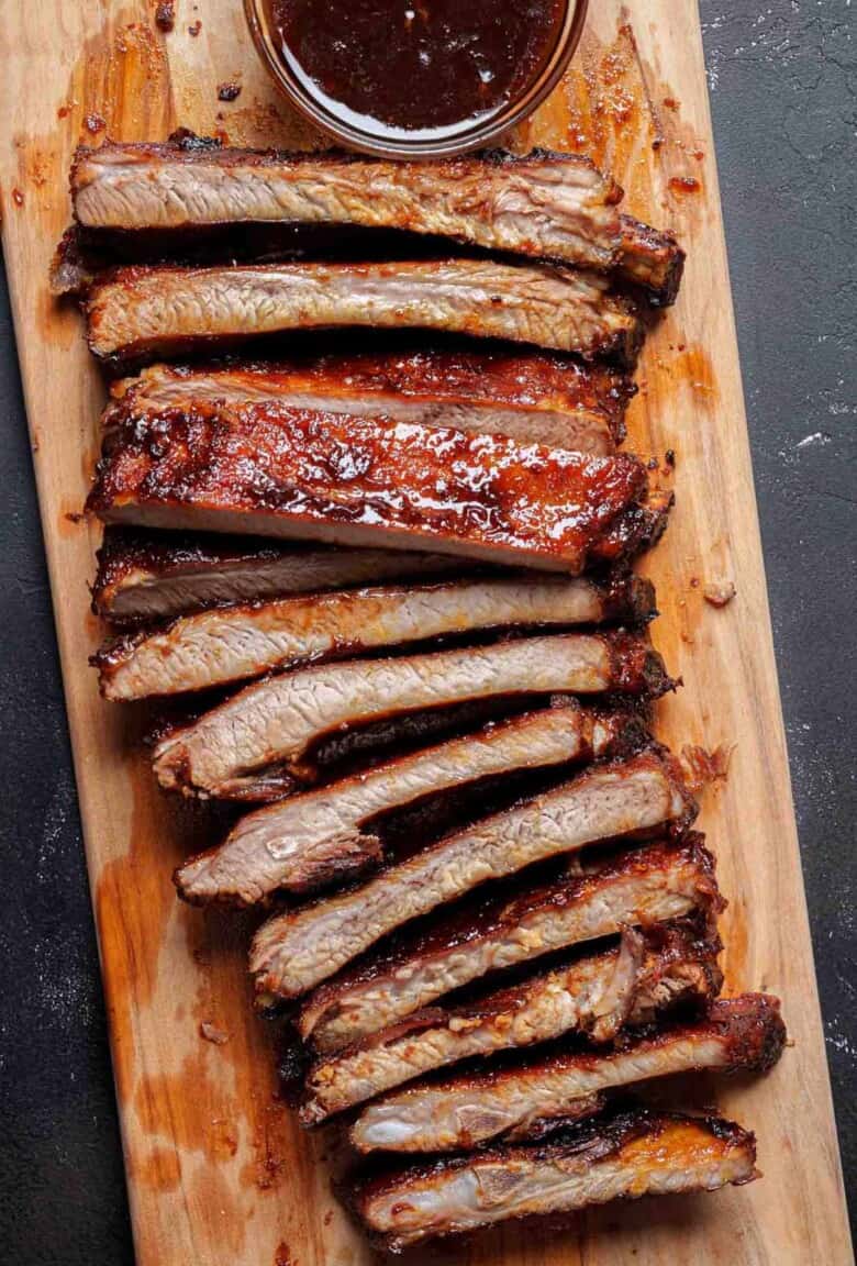 Image of sticky oven barbecue ribs beautifully arranged on a wooden tray.